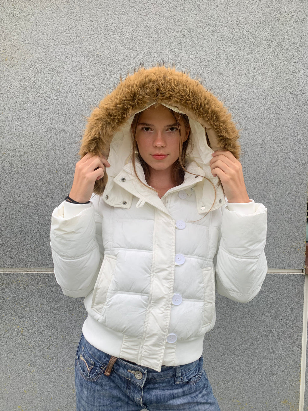 Down winter jacket with a hood trimmed with faux fur