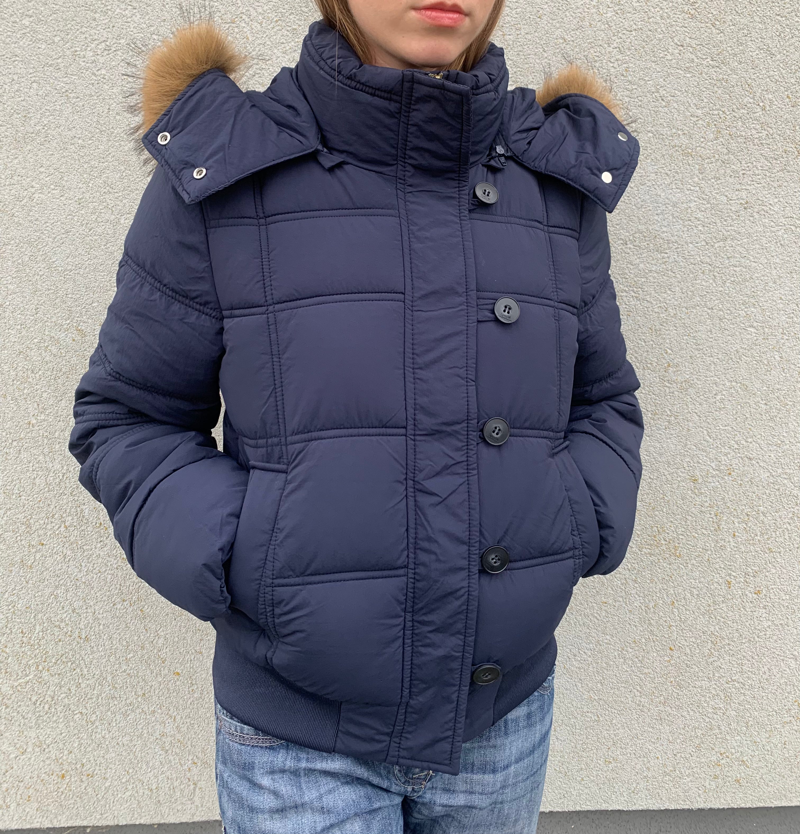 Down winter jacket with a hood trimmed with faux fur