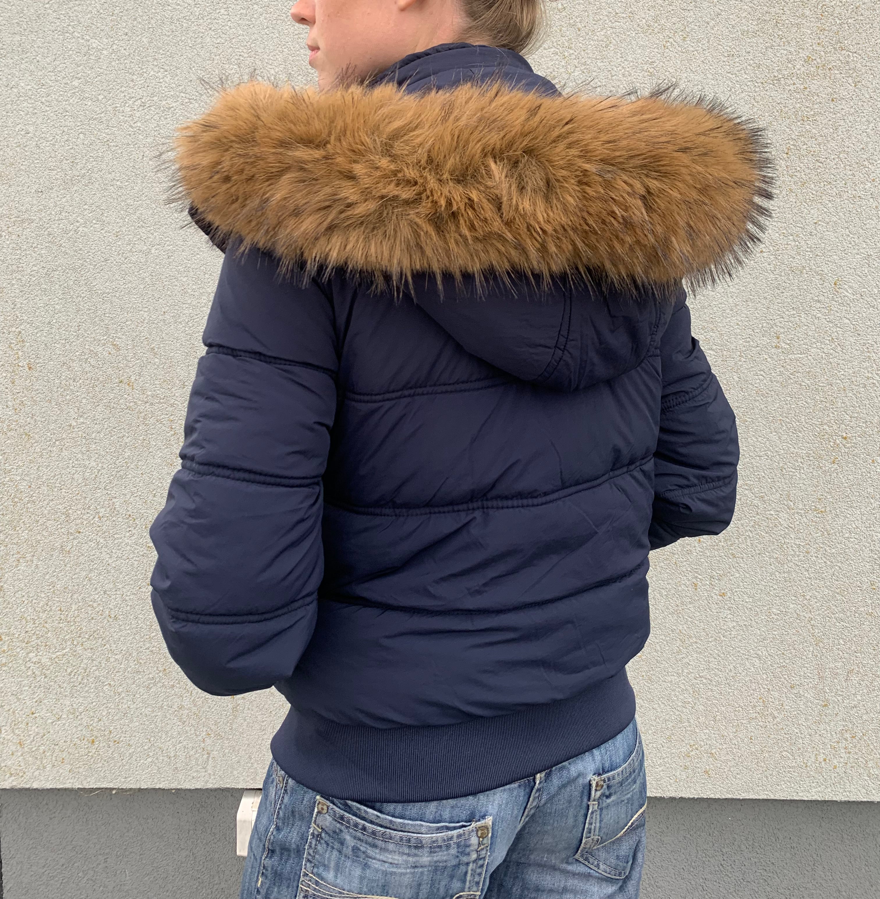 Down winter jacket with a hood trimmed with faux fur