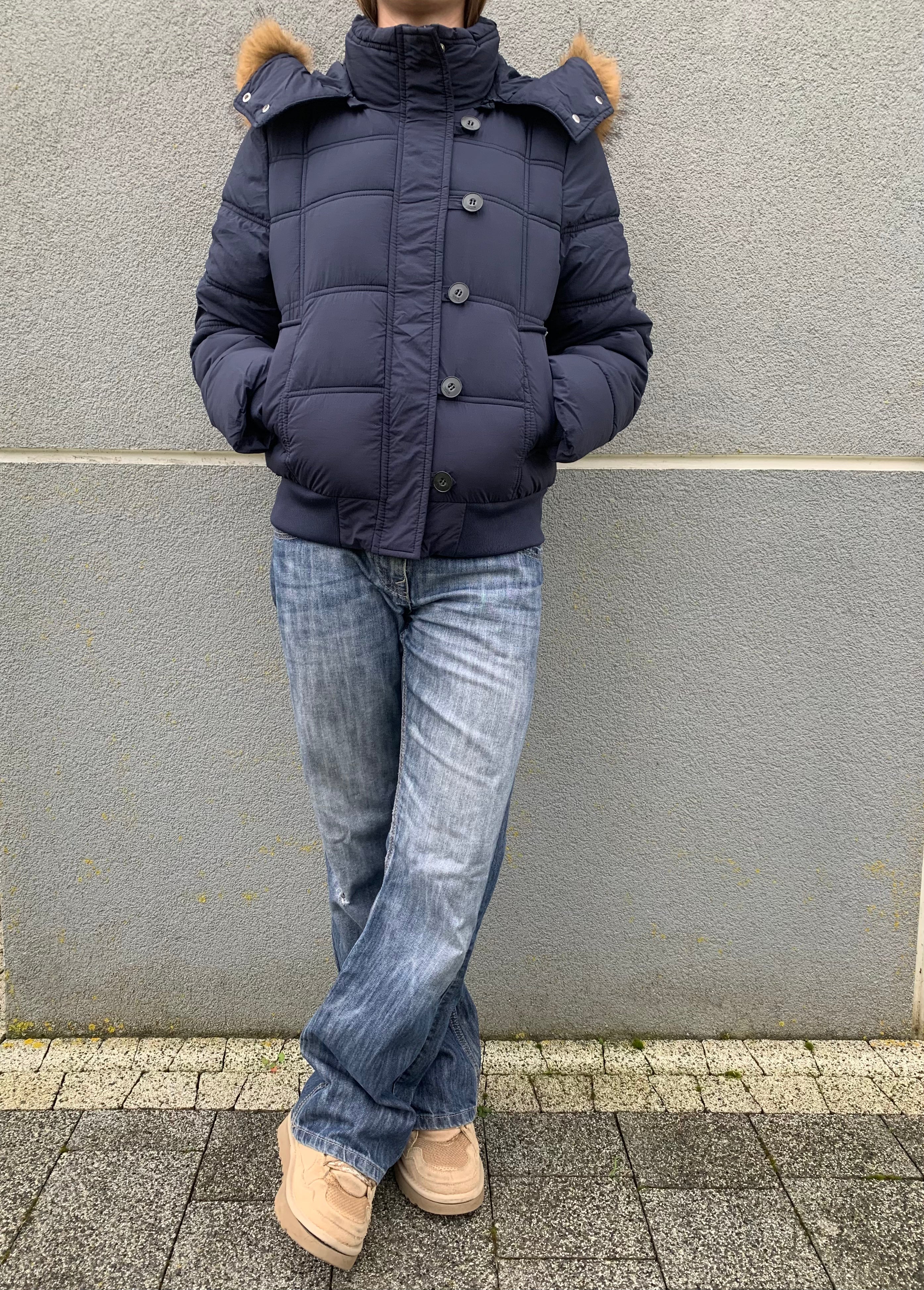 Down winter jacket with a hood trimmed with faux fur