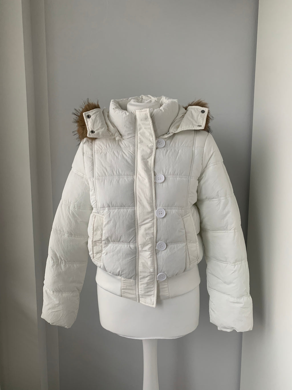 Down winter jacket with a hood trimmed with faux fur