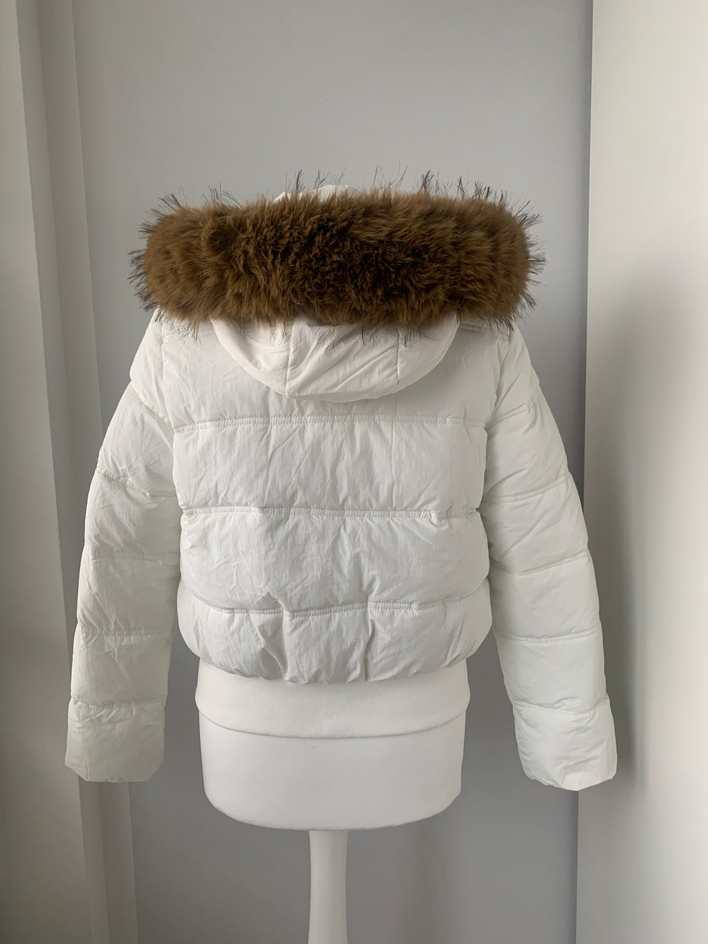 Down winter jacket with a hood trimmed with faux fur