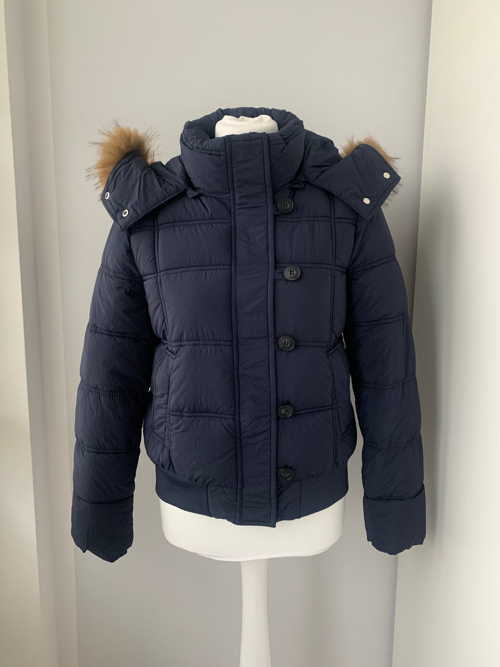 Down winter jacket with a hood trimmed with faux fur