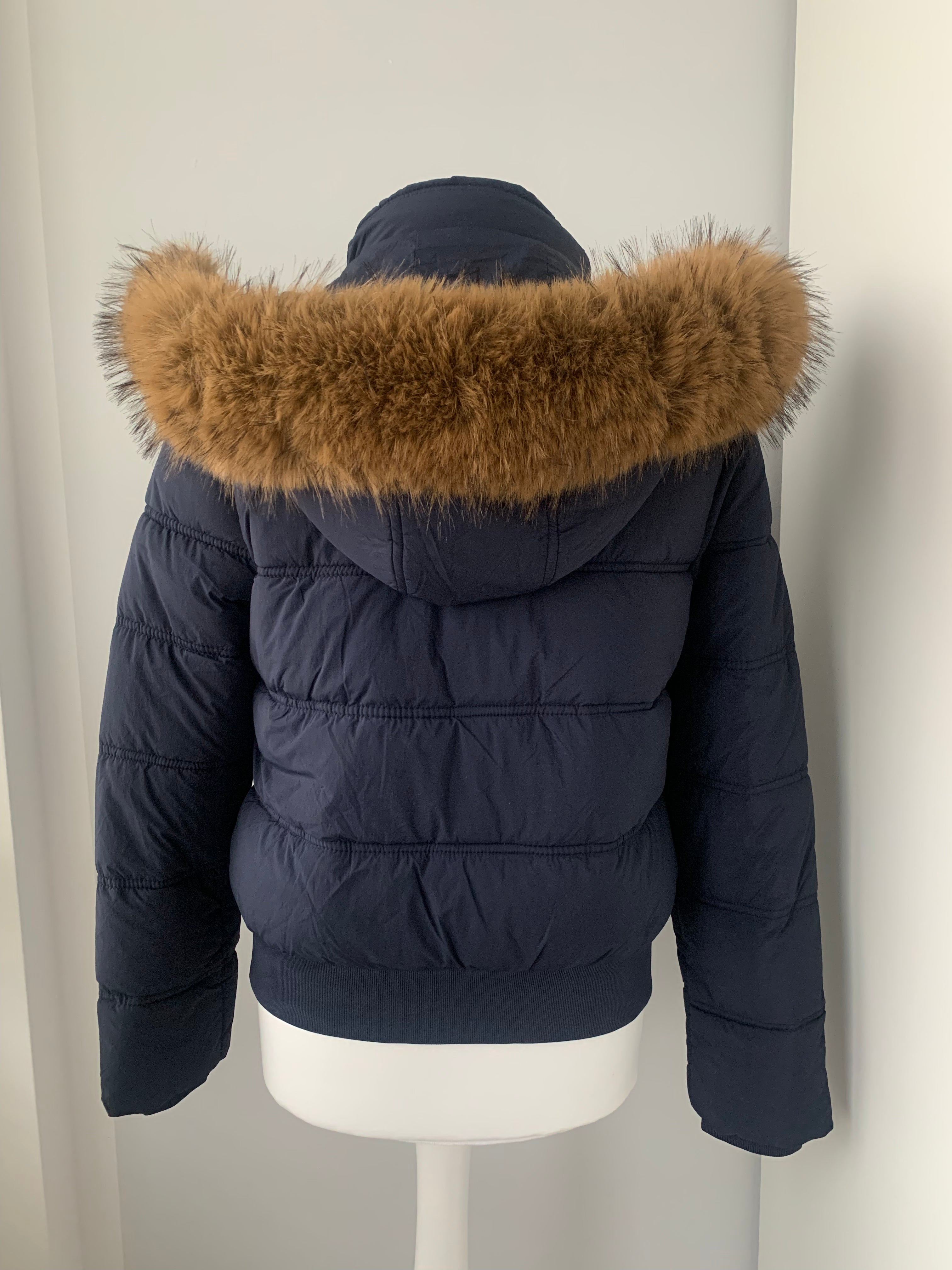 Down winter jacket with a hood trimmed with faux fur
